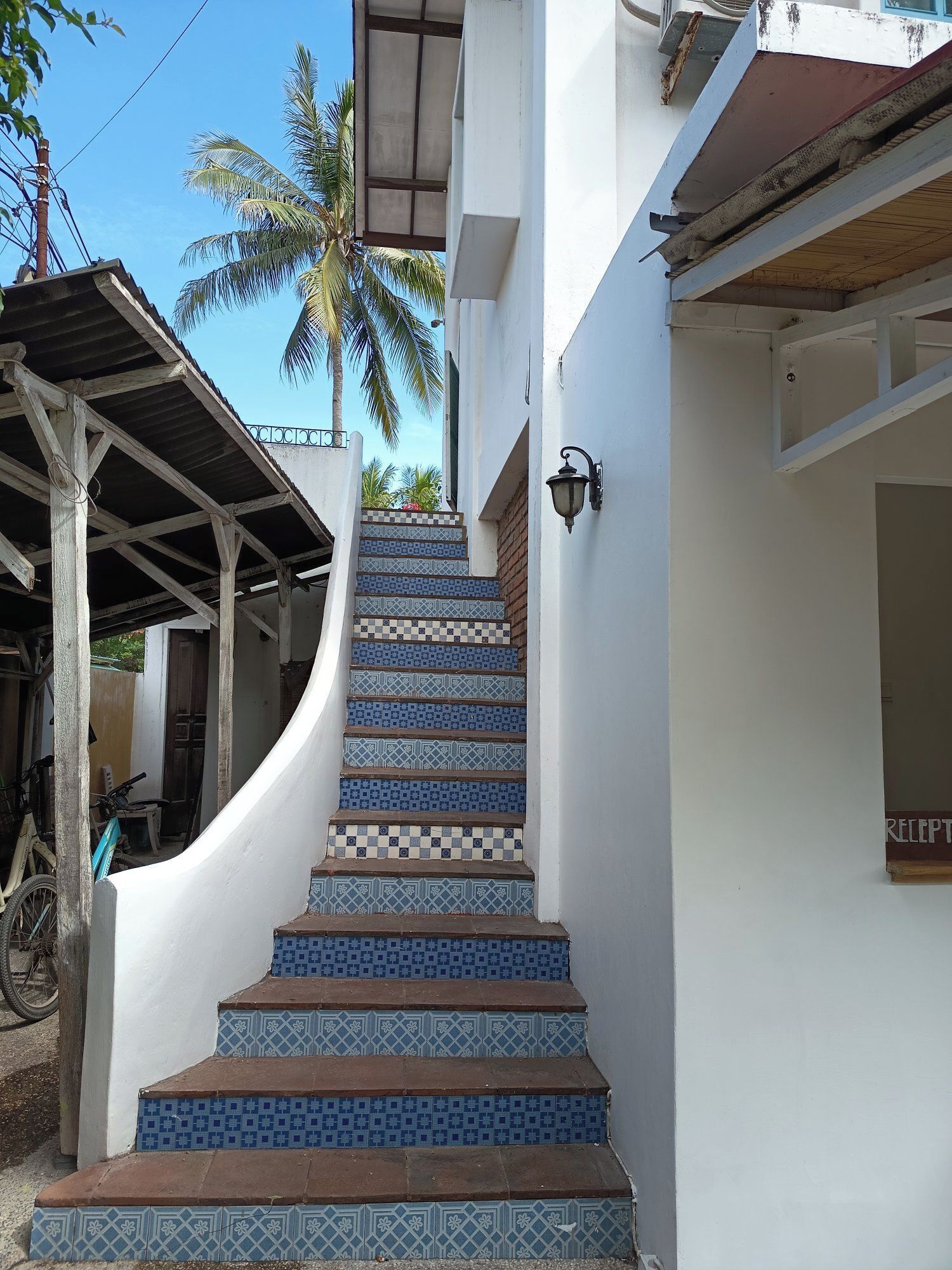 A staircase with blue and white patterned tiles leading up to a white building.