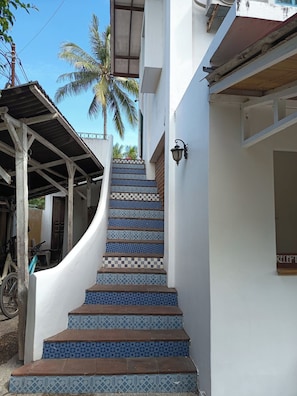A staircase with blue and white patterned tiles leading up to a white building. - White Coconut Resort (Gili Trawangan)