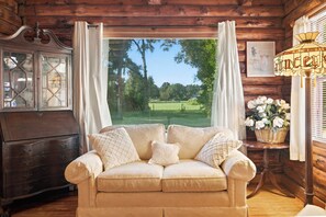 A cozy room with a sofa, a cabinet, and a lamp.