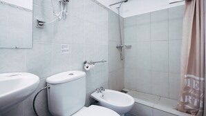 Une salle de bain équipée de toilettes, d’un bidet et d’une douche.