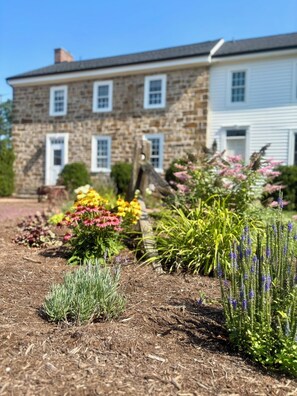 A stone building with a garden in front.