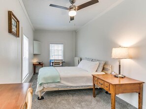 A bedroom with a bed, a desk, a chair, a ceiling fan, and a window. - Earthvine: Cozy Zen Retreat Pets-OK Downtown-ISU (Ames)