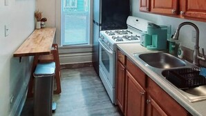 A compact kitchen with a stove, sink, and cabinets.