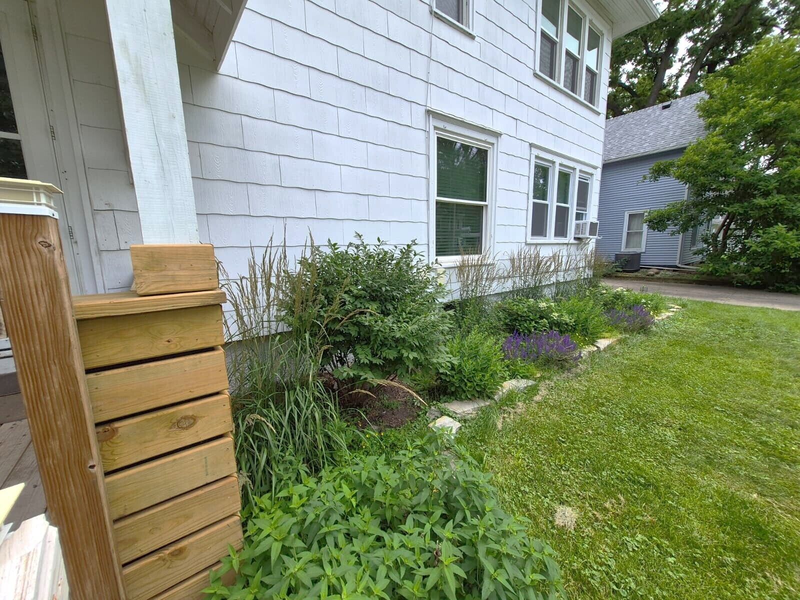 Ein Wohnhaus mit Garten, Holzzaun und freiem Blick auf die Vorderseite.