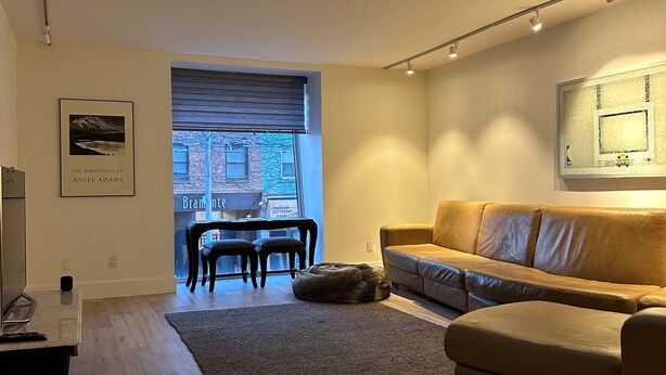 Een moderne woonkamer met een bank, een salontafel, een vloerkleed en een dakraam.