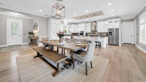 A spacious kitchen with white cabinets, a central island, and modern appliances. - 🦩Book Me Baby! Sea Breeze Escape in Santa Rosa Beach🦩 (Santa Rosa Beach)