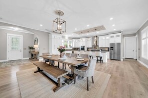 A spacious kitchen with white cabinets, a central island, and modern appliances. - 🦩Book Me Baby! Sea Breeze Escape in Santa Rosa Beach🦩 (Santa Rosa Beach)