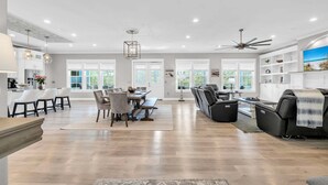 A spacious living area with a dining table, sofas, and a ceiling fan. - 🦩Book Me Baby! Sea Breeze Escape in Santa Rosa Beach🦩 (Santa Rosa Beach)