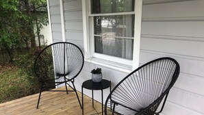A wooden deck with two black wire chairs and a small table with a potted plant. - Cozy Home: Fire Pit+Pets: near Riverside+Downtown (Jacksonville)