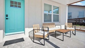A turquoise door, a window, and outdoor furniture.