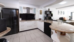 Una cucina moderna con frigorifero integrato, forno a microonde e macchina da caffè.