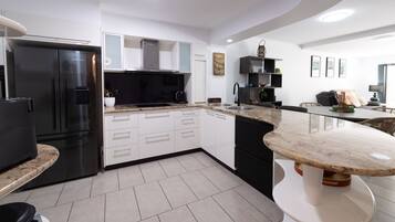 A modern kitchen with a built-in refrigerator, a microwave, and a coffee maker.