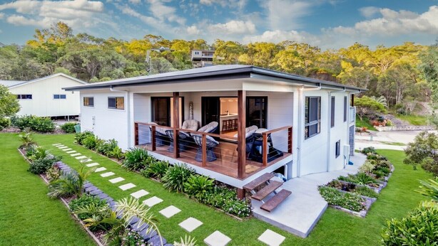 A modern two-story house with a covered porch, a well-maintained lawn, and a garden. - Coastal Haven - Agnes Water (Agnes Water)