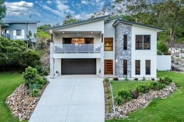 Contemporary house featuring spacious balcony, double garage, and landscaped entry, perfect for family comfort.