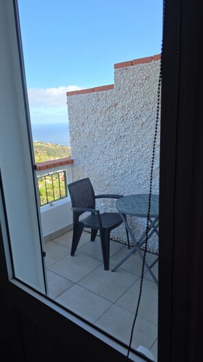 A balcony with a view of the sea, a table, and two chairs. - Ocean Heated Pool Jacuzzi View Executive201 (Santa Cruz)