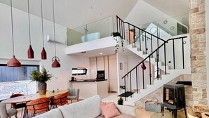 Een modern interieur met een trap, een eethoek en een open haard.