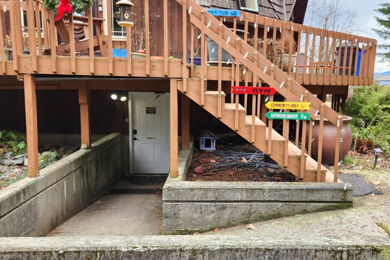A wooden deck with a staircase leading to a door labeled 'Community Area.'