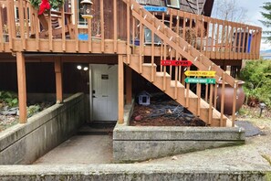 Une terrasse en bois avec un escalier menant à une porte indiquant « Espace communautaire ».