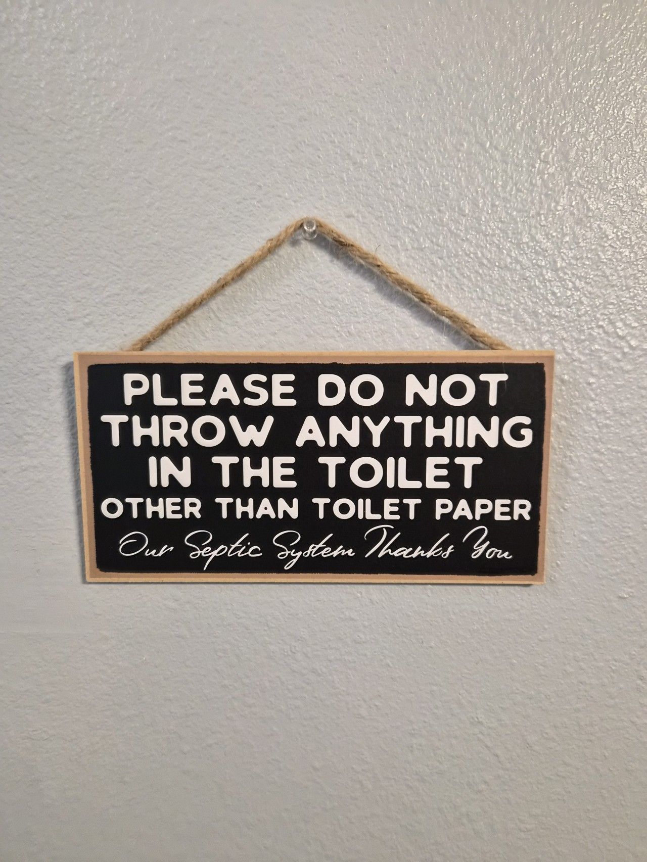 A sign with a humorous message about not throwing anything in the toilet except toilet paper.