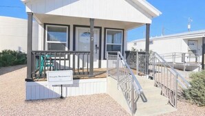 A small, single-story building with a porch, a staircase, and a sign indicating private residence.