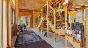 A wooden interior with a staircase, a rug, and a sofa.