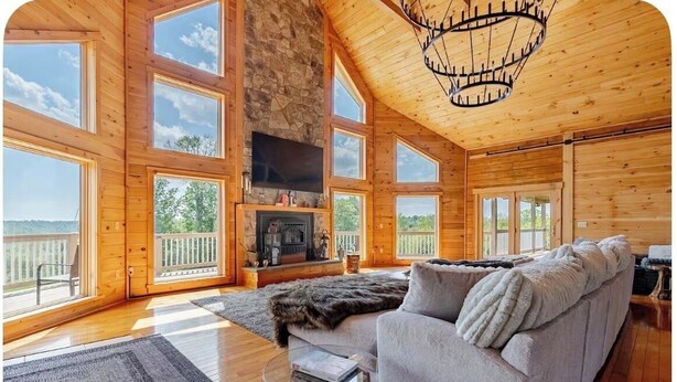 Une cabine spacieuse dotée de grandes fenêtres, d’une cheminée en pierre et d’un coin salon confortable.