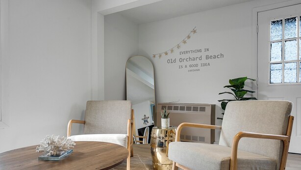 A room with a round wooden table, two armchairs, a large mirror, and a decorative wall with a quote. - Coastal Cottage STEPS to BEACH and downtown Old Orchard Beach - Prime Location (Old Orchard Beach)