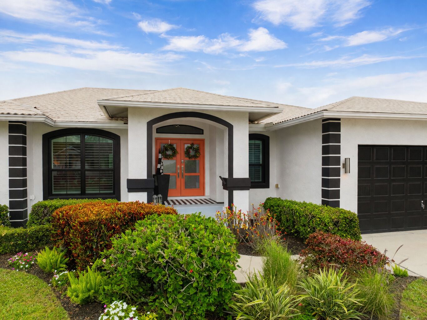 A modern house with a front porch, a garage, and a well-maintained garden.