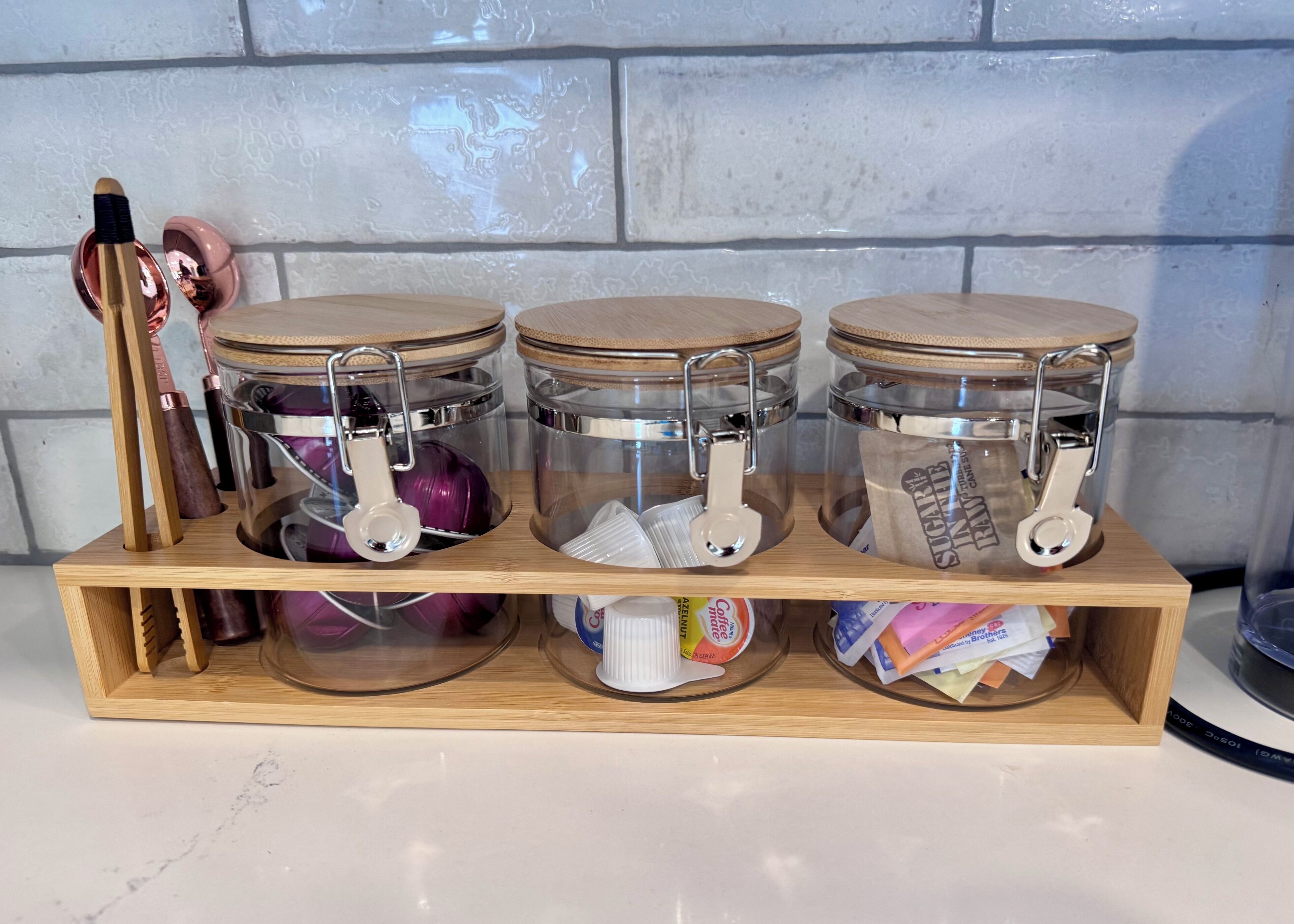 Three glass jars with wooden lids on a wooden shelf.