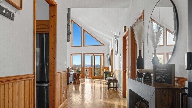 Eine geräumige Küche mit Holzboden, einem Kühlschrank und einer Essecke mit einer Bank.