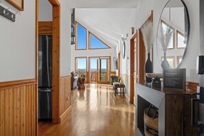 Eine geräumige Küche mit Holzboden, einem Kühlschrank und einer Essecke mit einer Bank.