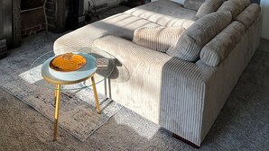 Un salon comprenant un canapé, une table basse en verre, une cheminée et un téléviseur affichant des graphiques financiers.