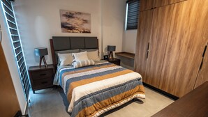 Ein Schlafzimmer mit Bett, Nachttischen, einem Kleiderschrank und einem Bild an der Wand.