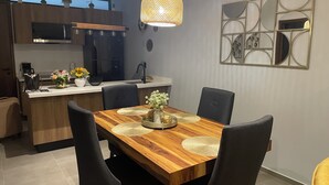 Eine moderne Küche mit einem Holztisch, schwarzen Stühlen und einer Wanddekoration.