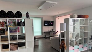 Un salon moderne comprenant un canapé, un téléviseur, un bureau et une bibliothèque.