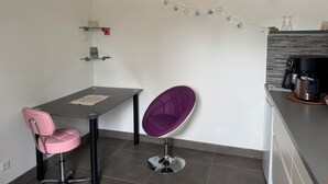 Une cuisine moderne avec un coin repas comprenant une table, des chaises et une machine à café.