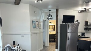 Une cuisine moderne équipée d’un réfrigérateur, d’une table à manger et d’un coin salon avec un canapé et une table basse.
