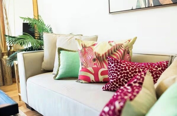 Un sofá con varios cojines de diferentes estampados y colores.