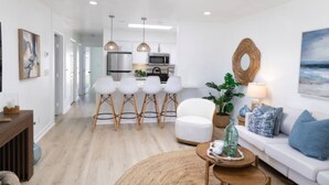 A modern apartment with a kitchen, dining area, and living room. - The Orkney - A Modern Coastal Cardiff Residence (Encinitas)