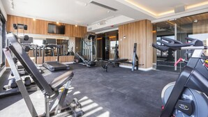 Uma academia moderna com máquinas de cardio, equipamentos de musculação e um painel de espelhos.