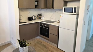 Cozinha compacta com micro-ondas, torradeira e forno.