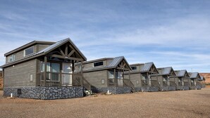 A row of cabins with stone foundations, wooden exteriors, and metal roofs. - Cozy Tiny Home with Loft Sleeps 6 (Page)