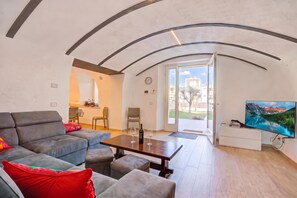 A modern living room with a sofa, a coffee table, and a television. - Peschiera few steps from the lake Garden, Terrace, & AC, Peschiera del Garda, Italy (Peschiera del Garda)