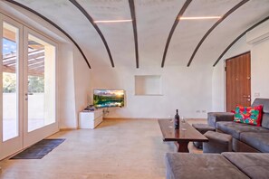 Een moderne woonkamer met een flatscreen televisie, een bank, een salontafel en een houten vloer.