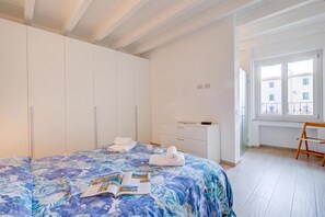 A bedroom with a bed, a bedside table, a window, and a wooden chair. - Peschiera few steps from the lake Garden, Terrace, & AC, Peschiera del Garda, Italy (Peschiera del Garda)