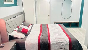 A bedroom with a bed, a chair, a desk, a wardrobe, a mirror, and a door. - Modern Private Suite with 100 inch TV Quiet Oshawa (Oshawa)