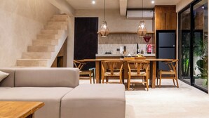 Ein modernes Interieur mit Treppe, Essbereich und Küche.