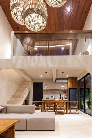 Um interior moderno com escada, área de refeições e cozinha.