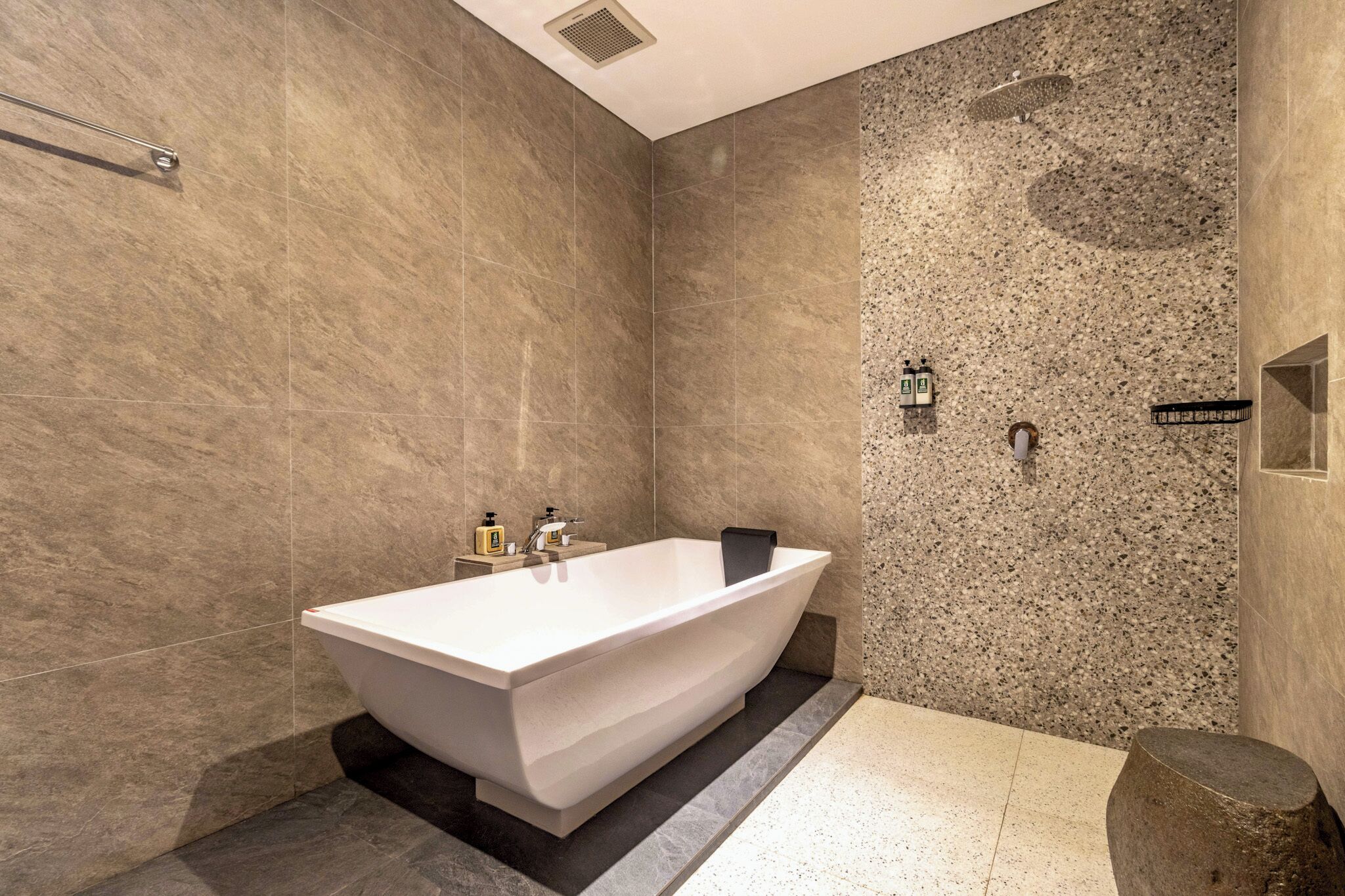 Une salle de bain moderne avec une baignoire sur pieds, une pomme de douche et un porte-serviettes.
