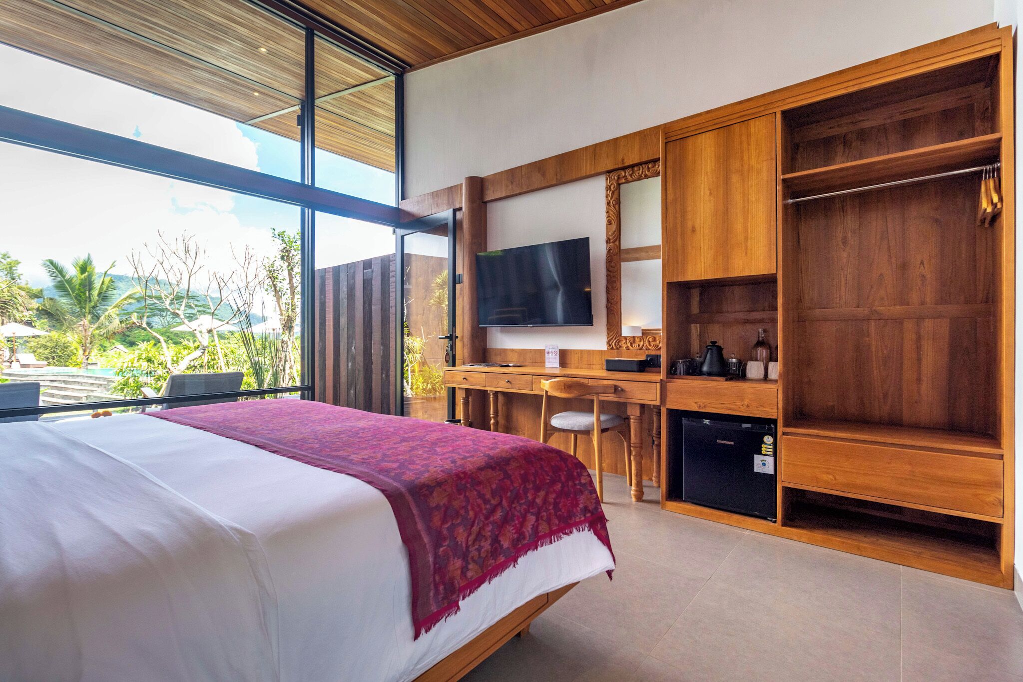 Un dormitorio con cama, escritorio, televisión y armario.